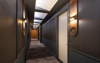 a long hallway with dark wood walls and white doors